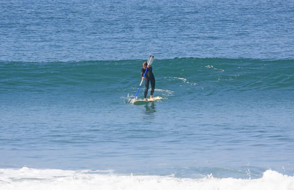 A paddle surfer catching a wave in San Diego