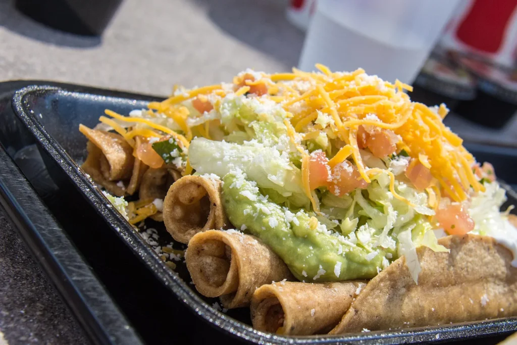 Rolled tacos topped with guacamole and cheese