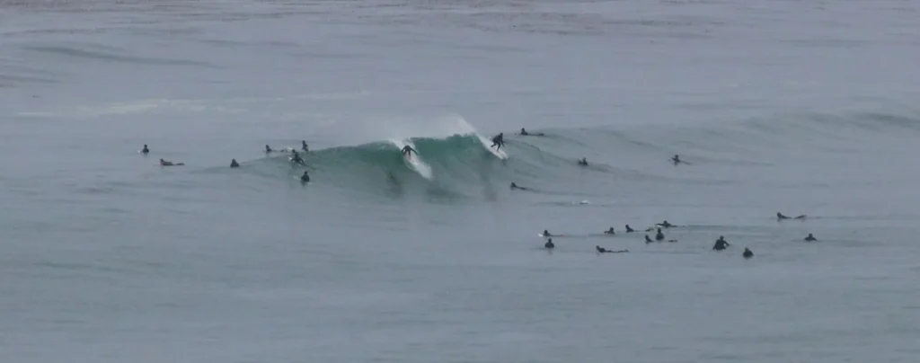Surfers waiting for waves at the main peak at Swamis in Encinitas