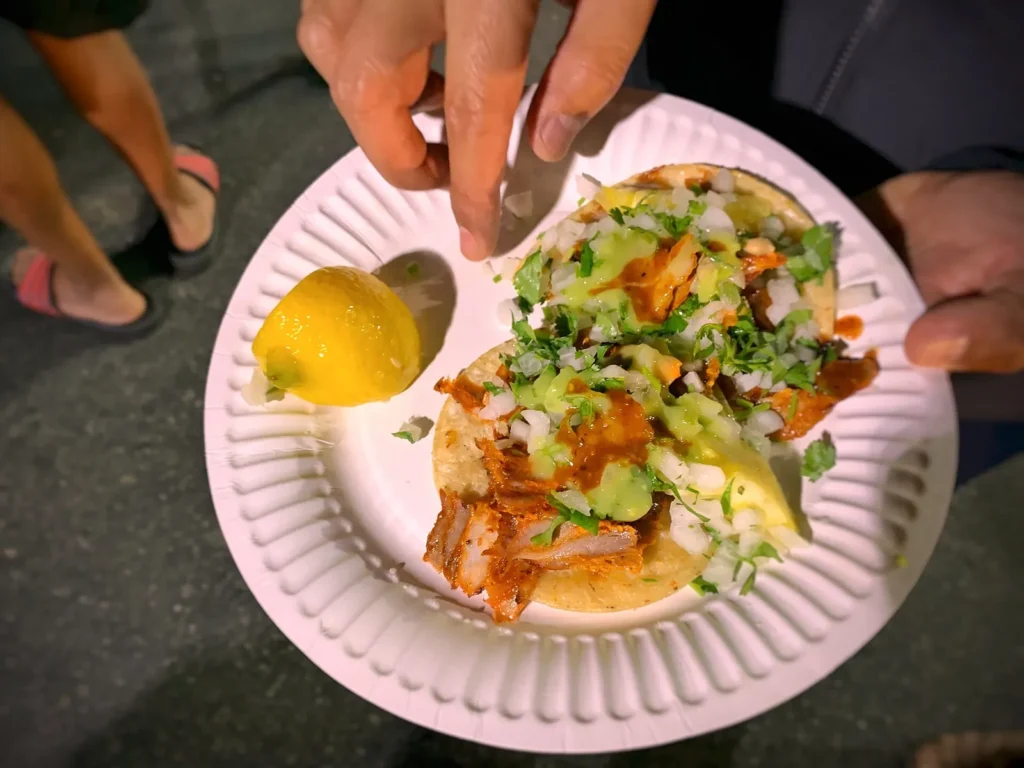 Tacos al pastor on a paper plate