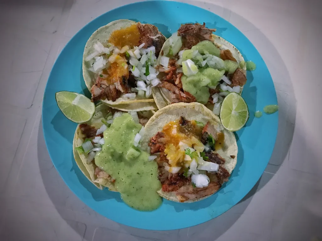 Tacos al pastor topped with pineapple and cilantro